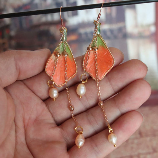 Handmade Ronghua orange-green silk velvet leaf long drop earrings with pearl chain and gold details hanging on display