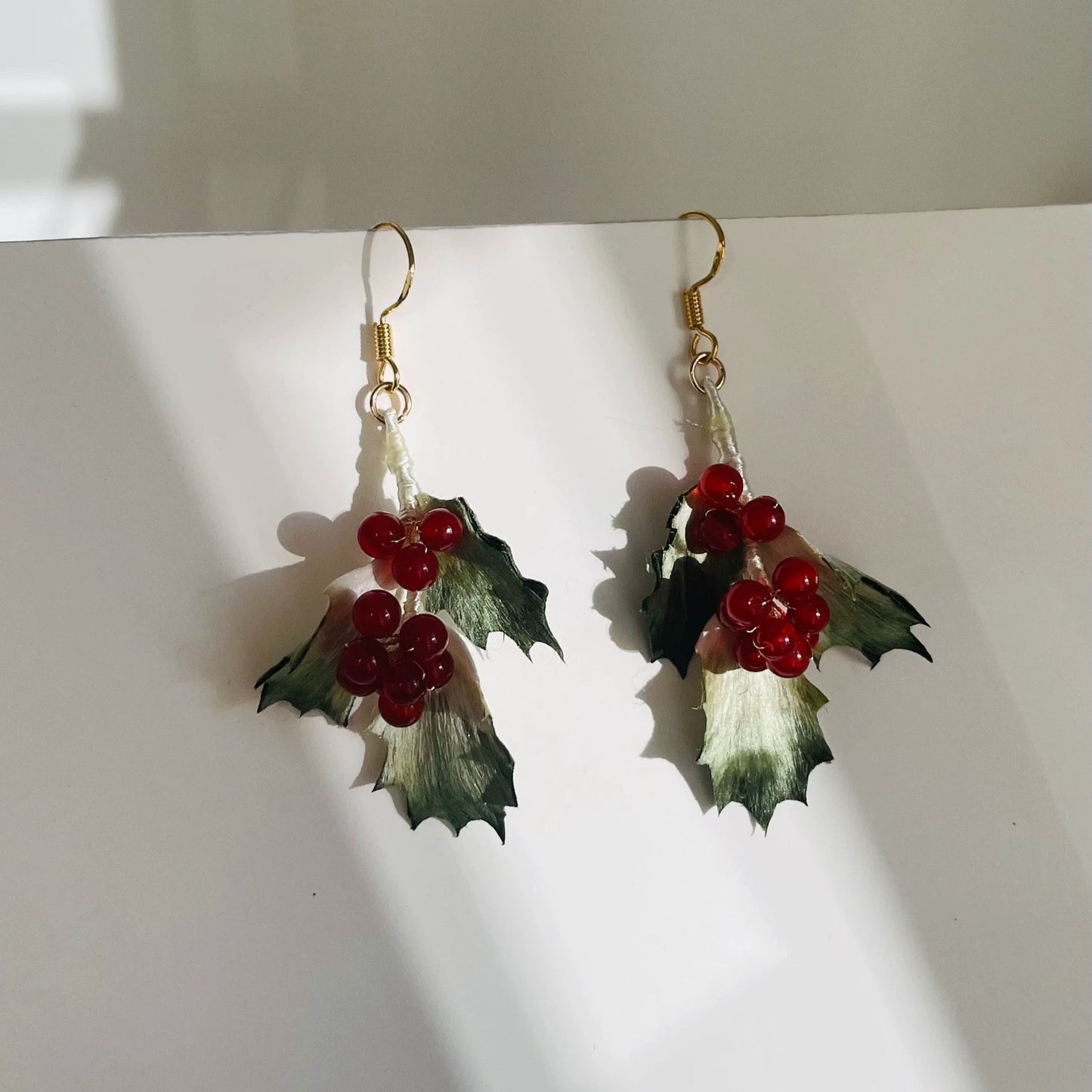 Handmade Ronghua winter holly drop earrings in green mulberry silk velvet leaves with red berry clusters on gold hooks