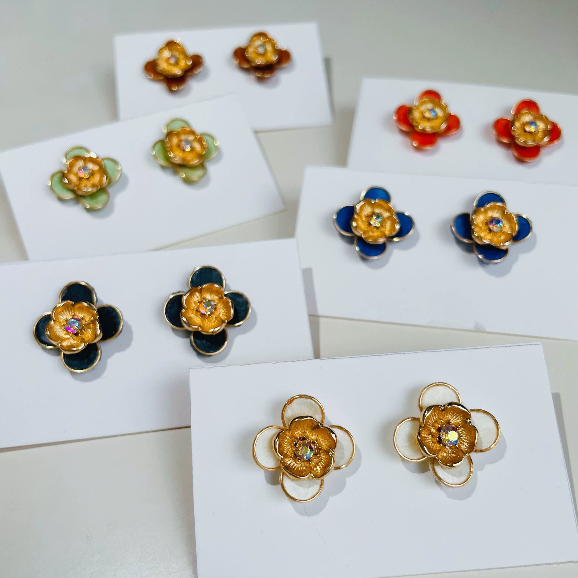 Handmade Ronghua plum blossom stud earrings collection in 8 colors of mulberry silk velvet with crystal center, displayed on white cards