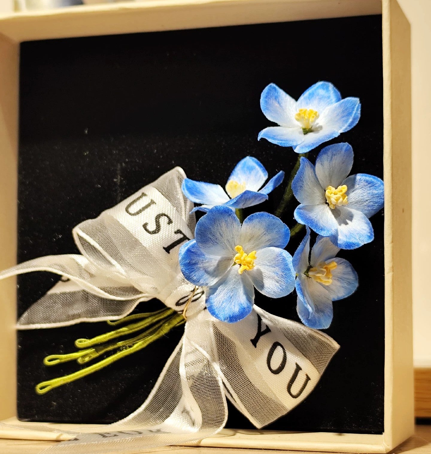 Close-up of sky-blue Ronghua silk star flowers tied with sheer white ribbon