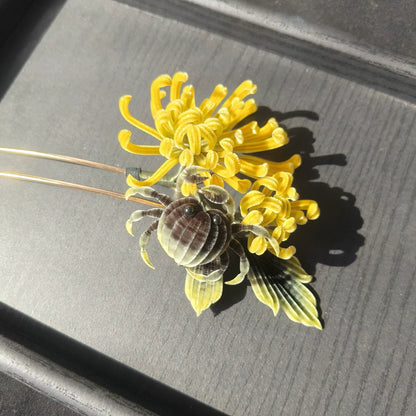 Handmade Ronghua chrysanthemum crab hairpin with yellow silk flower and black crab detail on dark tray