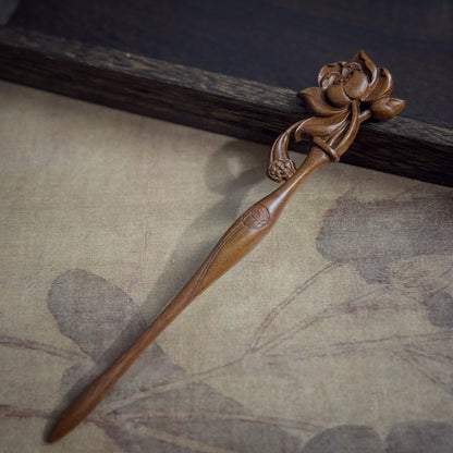 Natural Golden Phoebe hair stick with floating lotus carving 19.8cm on textured background.